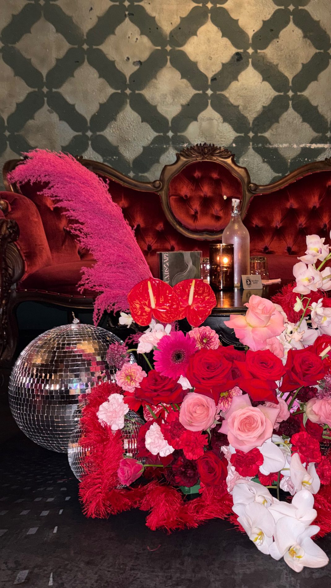 Original red and pink floral installation with roses and orchids at an event
